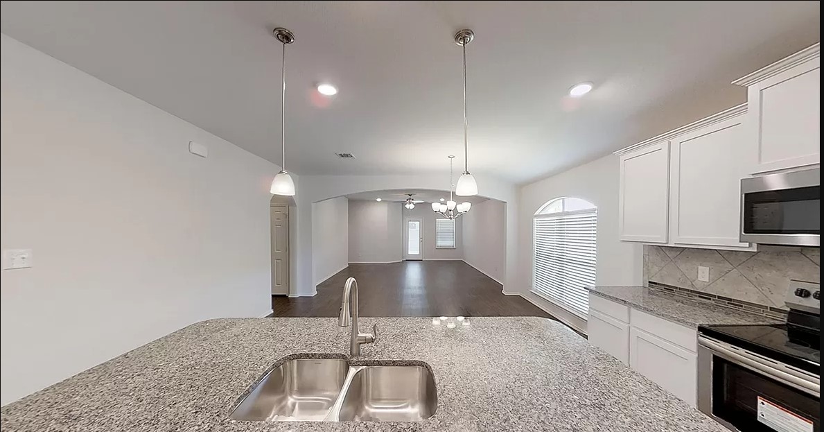 1828 T H Johnson Drive Taylor, TX 76574 - Photo 3 of 11 a large kitchen with kitchen island a sink stainless steel appliances and cabinets