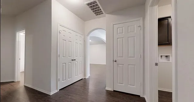 a view of a hallway with wooden floor