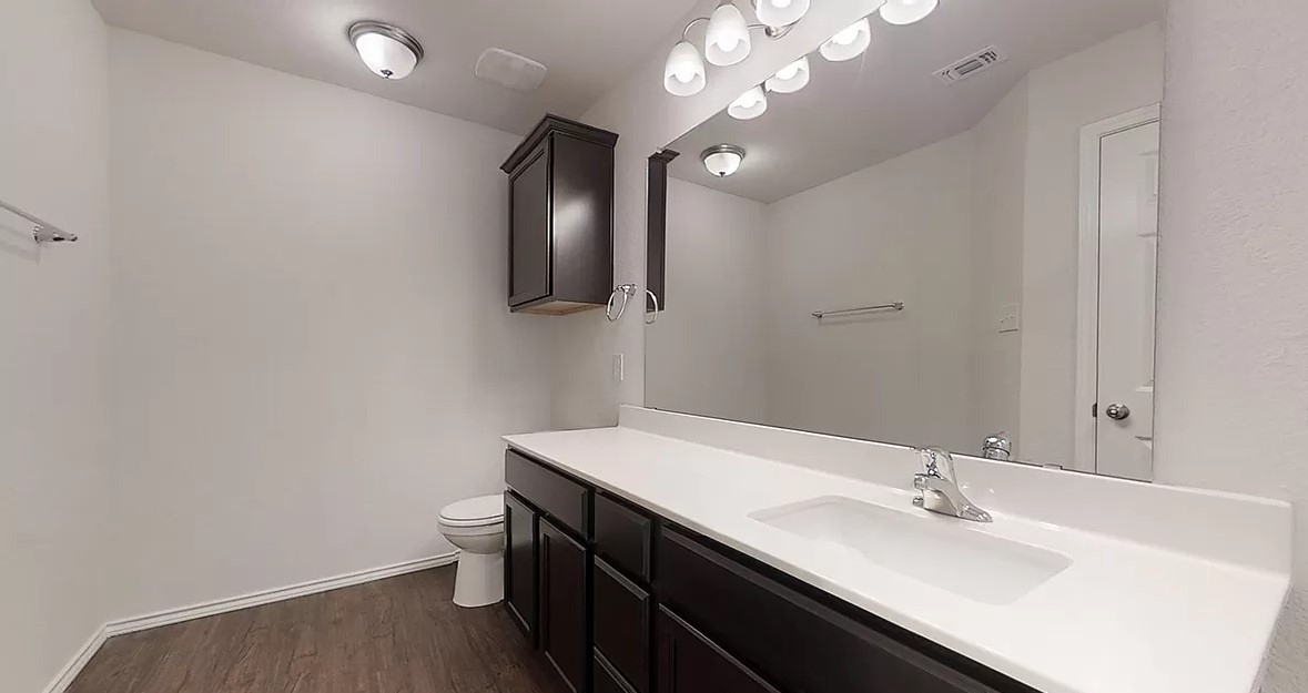 1828 T H Johnson Drive Taylor, TX 76574 - Photo 10 of 11 a bathroom with a sink a light fixture and a mirror