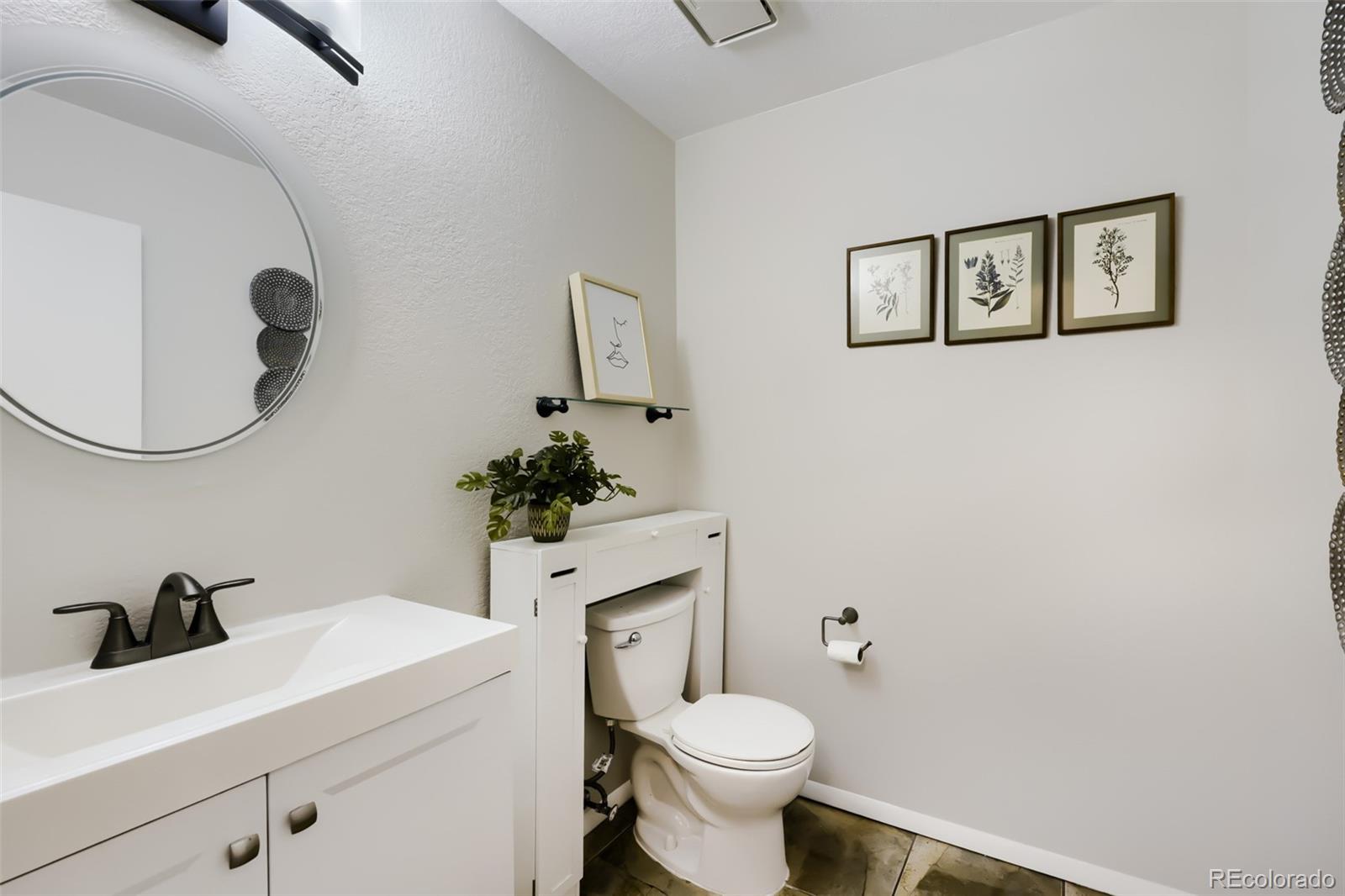 175 Xenon Street Denver, CO 80228 - Photo 13 of 37 a bathroom with a toilet a sink and mirror