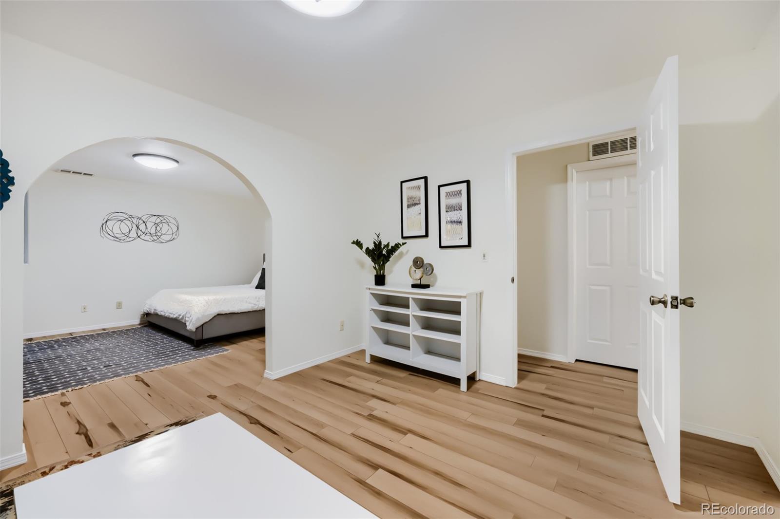 175 Xenon Street Denver, CO 80228 - Photo 22 of 37 a bedroom with a bed and wooden floor