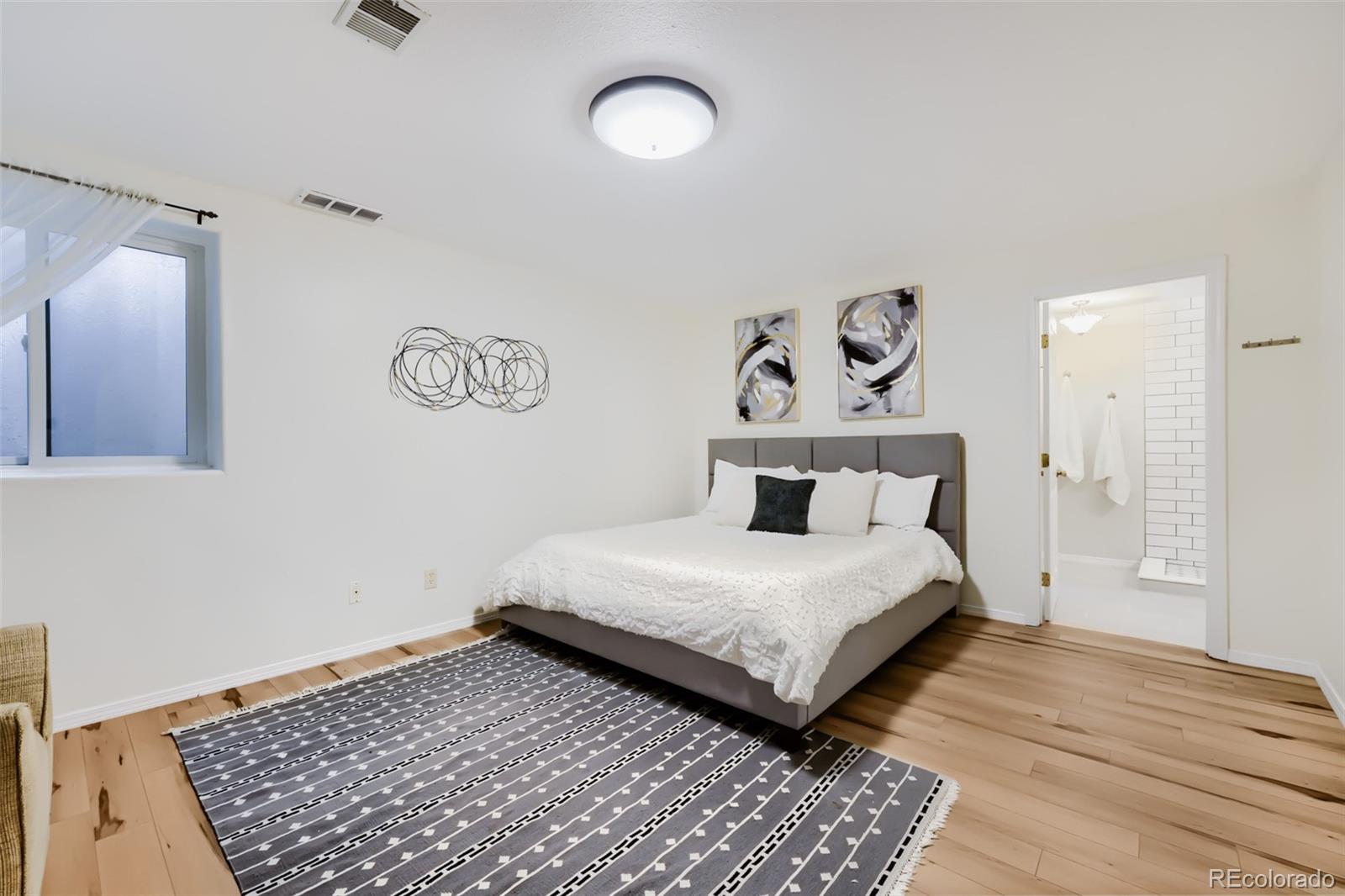 175 Xenon Street Denver, CO 80228 - Photo 23 of 37 a bedroom with a bed and wooden floor