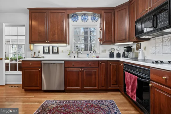 a kitchen with stainless steel appliances granite countertop a sink stove and cabinets