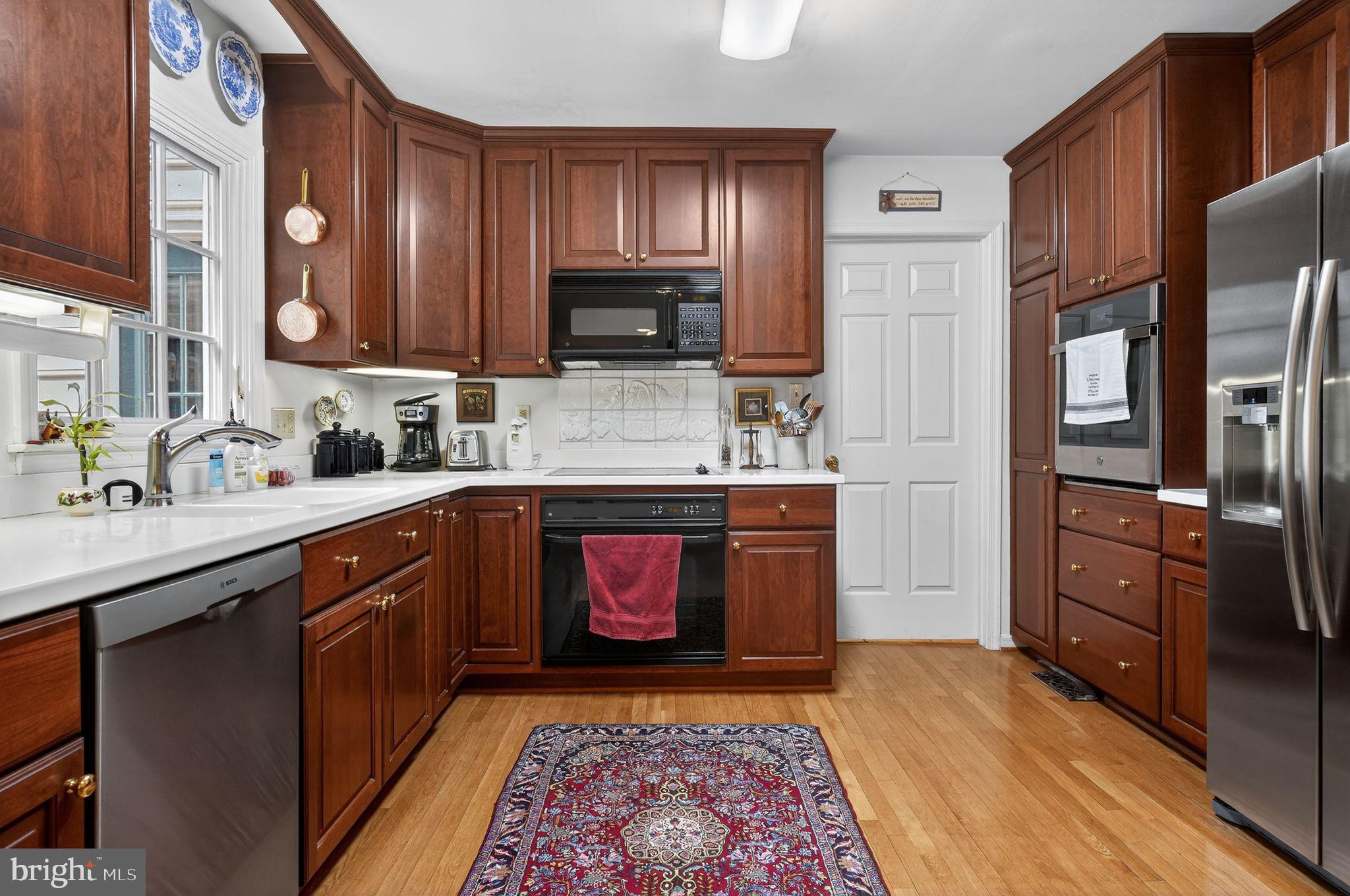 1510 Eton Way Crofton, MD 21114 - Photo 20 of 51 a kitchen with stainless steel appliances granite countertop a refrigerator a stove top oven and sink with wooden floor