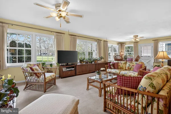 a living room with furniture a flat screen tv and a large window