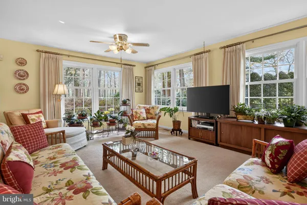 a living room with furniture a flat screen tv and a large window