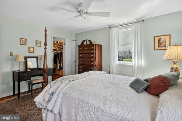 a bedroom with a bed and dresser with chair
