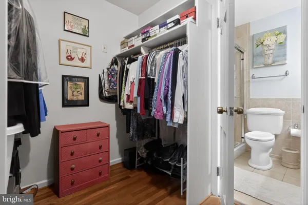 a view of walk in closet with clothes and shoes