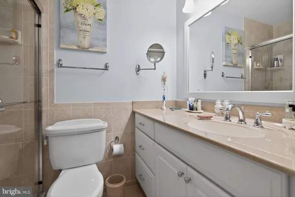 a bathroom with a granite countertop toilet sink and mirror