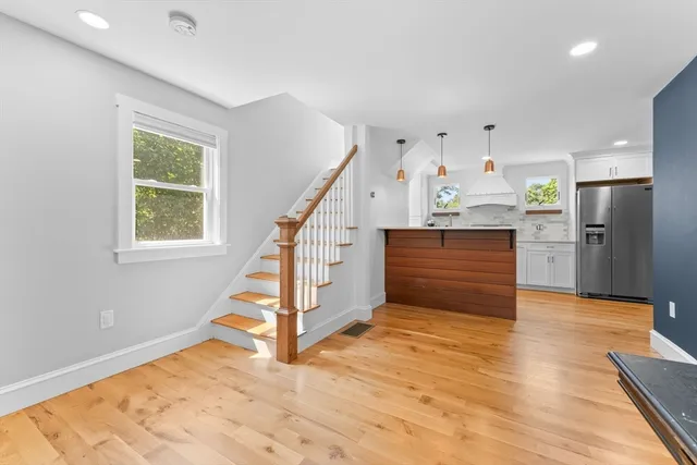 a view of a hallway with wooden floor and staircase