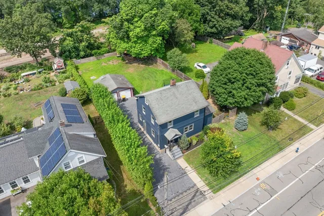 an aerial view of a house with garden space and street view