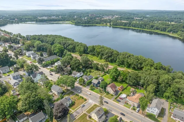 an aerial view of a house with a yard and lake view