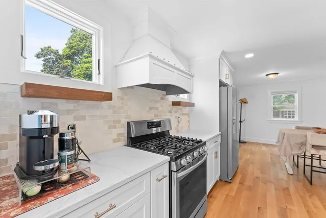 a kitchen with granite countertop a stove and a wooden floors