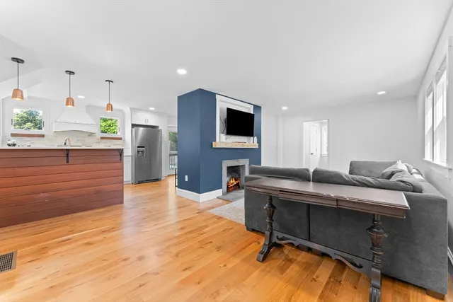 a living room with furniture a flat screen tv and kitchen view