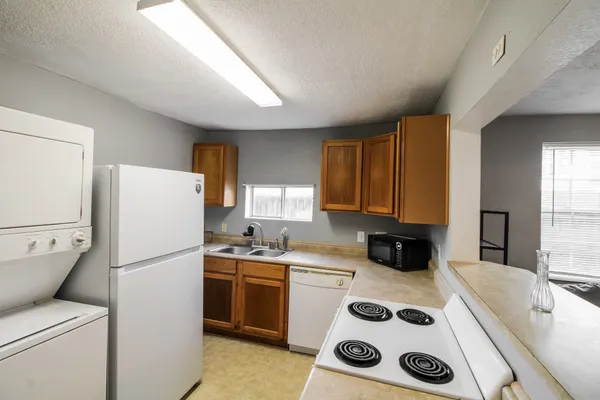 a kitchen with a refrigerator a sink and white cabinets