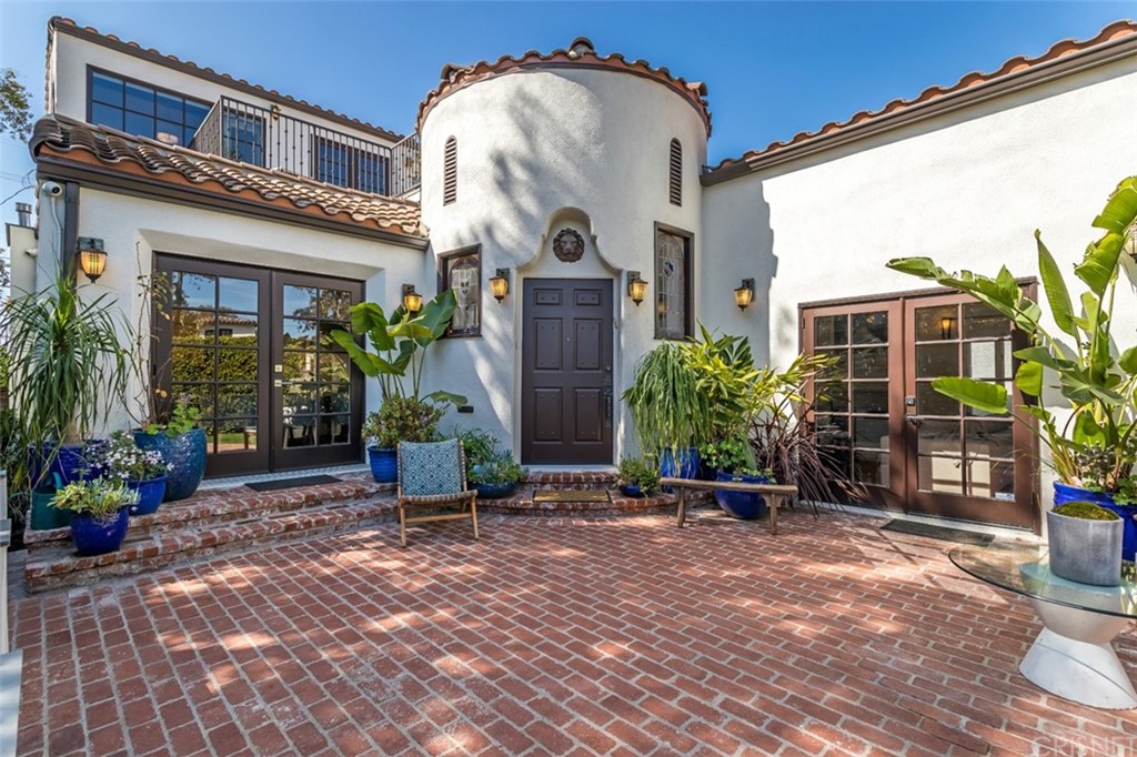 Extensively updated majestic Spanish-style house in Beverly Grove on a private fully gated and hedged-in oasis with expansive outdoor living in both the front and back yards.