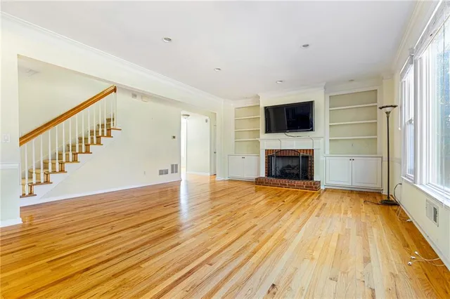 a view of empty room with wooden floor and fireplace