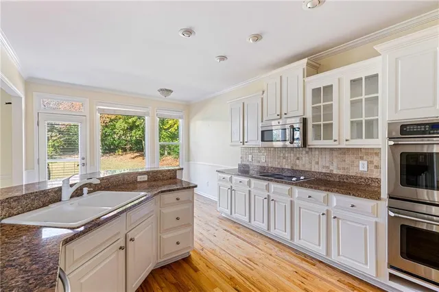 a kitchen with granite countertop a sink stove and cabinets