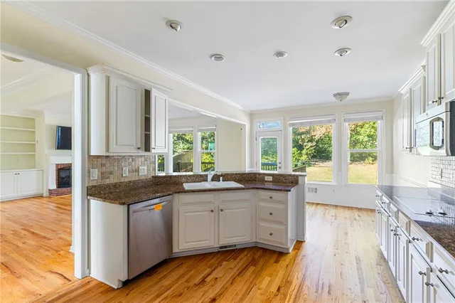 a kitchen with granite countertop a sink stove and cabinets