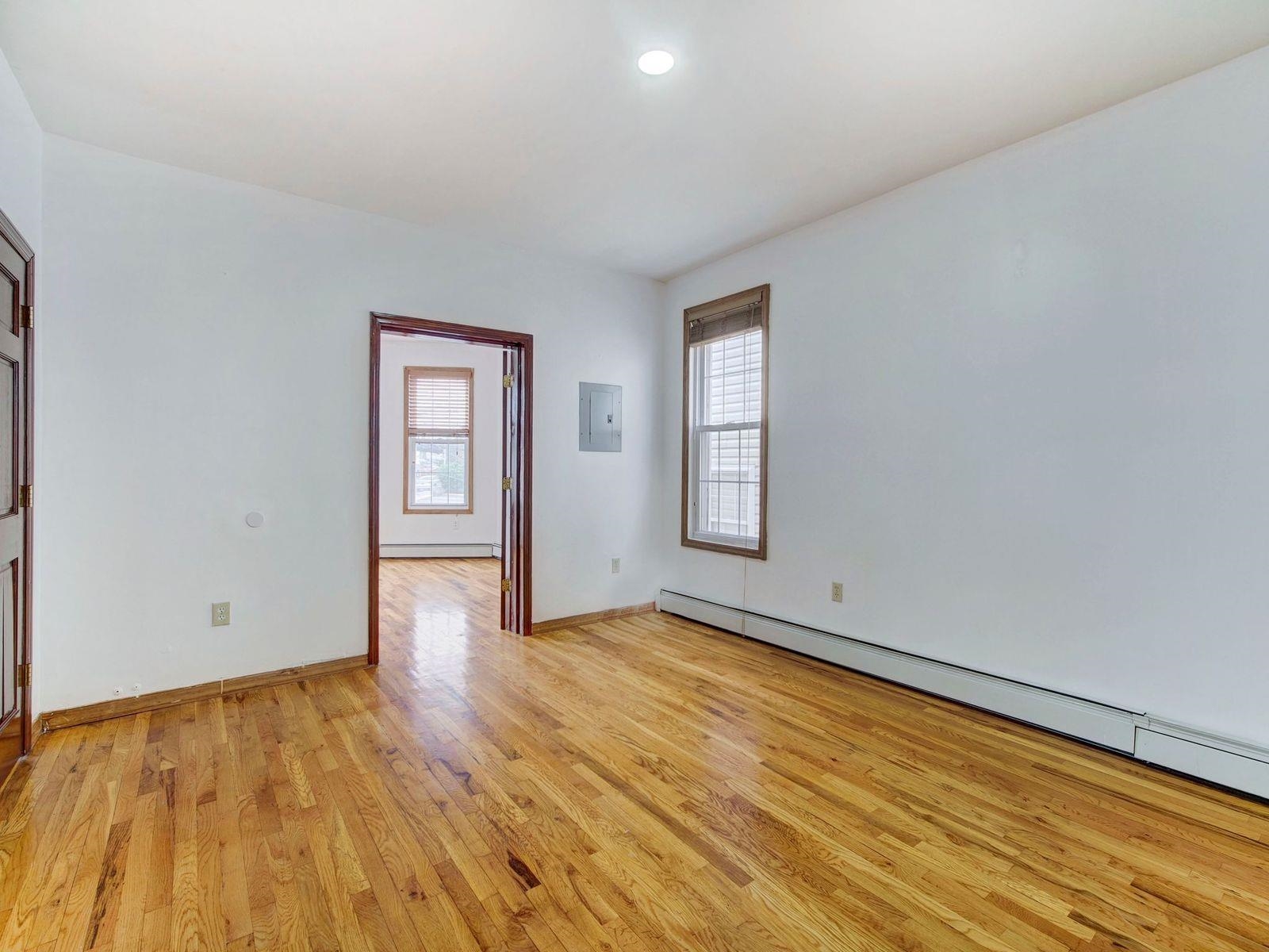 921 Paterson Plank Road, Unit 2 North Bergen, NJ 07047 - Photo 7 of 15 a view of an empty room with wooden floor and a window