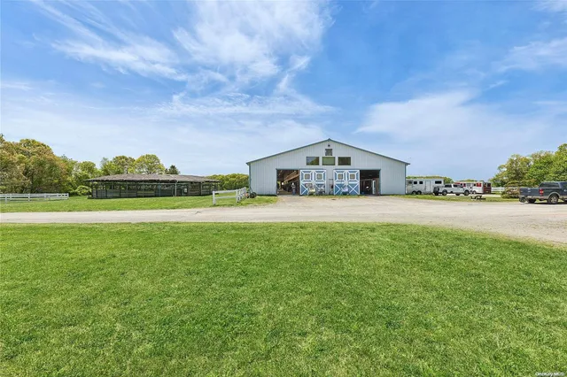 a view of a big house with a big yard and palm trees
