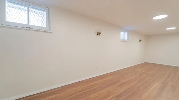 a view of an empty room with closet and wooden floor