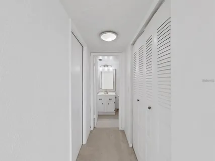 a view of a hallway with white walls and stairs
