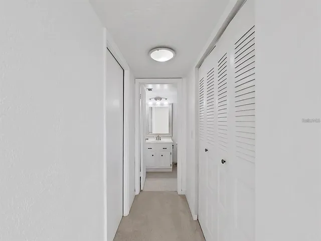 a view of a hallway with white walls and stairs