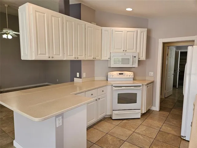 a kitchen with white cabinets and white appliances