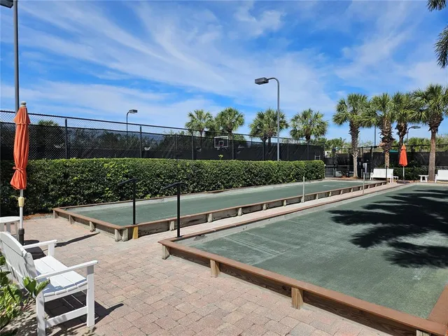 a view of a tennis ground with large trees