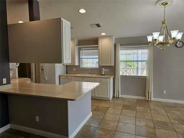 a kitchen with kitchen island cabinets a counter top space and a sink
