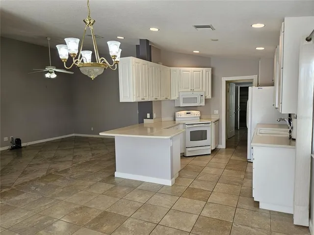 a large kitchen with kitchen island a sink stainless steel appliances and cabinets