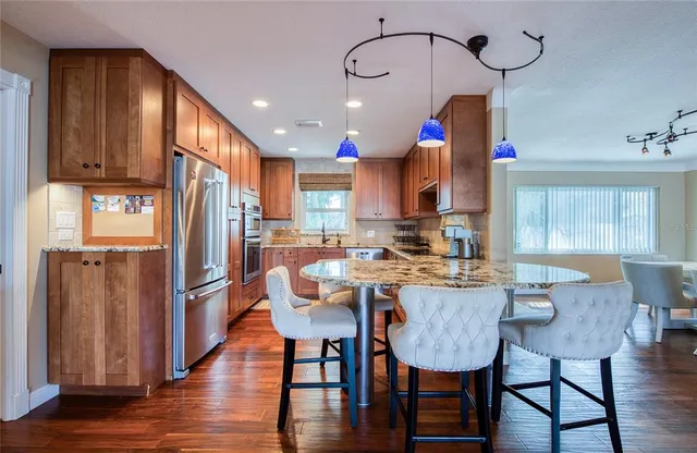 a kitchen with a dining table chairs and wooden floor