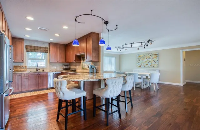 a kitchen with granite countertop wooden cabinets stainless steel appliances and a window