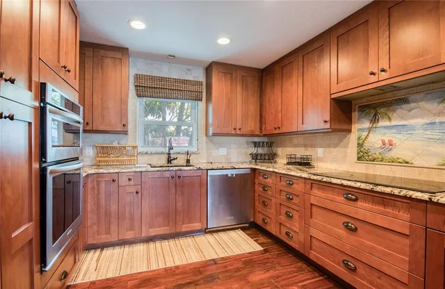 a kitchen with stainless steel appliances granite countertop a stove a sink and a microwave