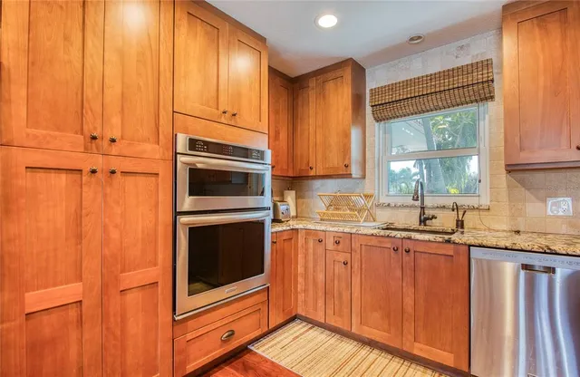 a kitchen with granite countertop wooden cabinets and white appliances