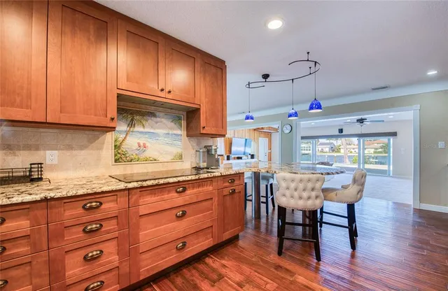 a kitchen with granite countertop wooden cabinets stainless steel appliances and a window