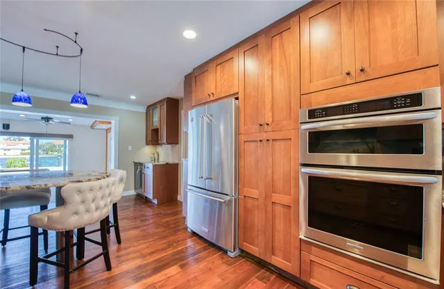 a kitchen with kitchen island granite countertop wooden cabinets and a refrigerator