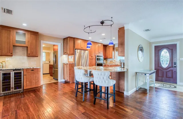 a kitchen with stainless steel appliances granite countertop a kitchen island a table and chairs