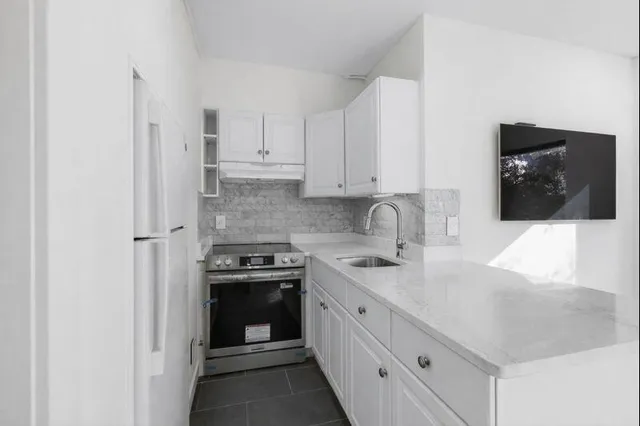 a kitchen with stainless steel appliances granite countertop a sink and a stove