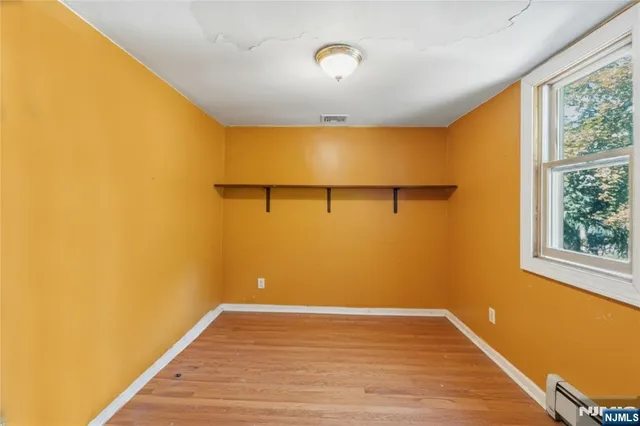 a view of a room with wooden floor and a window