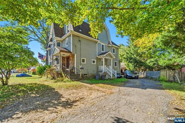 a view of a house with a yard and pathway