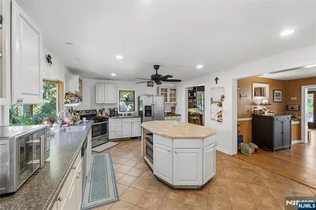 a large kitchen with sink a counter top space stainless steel appliances and cabinets
