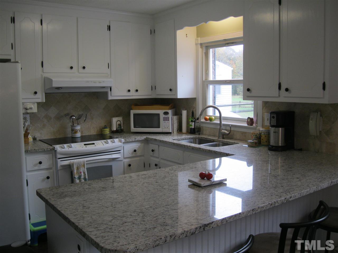 6107 Jackson Road Rougemont, NC 27572 - Photo 7 of 25 a kitchen with a stove a sink and a white cabinets