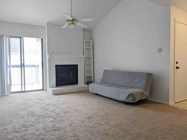 a view of an empty room with a fireplace and a window