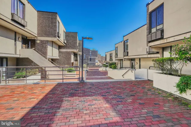 a view of a white house with a small yard and plants