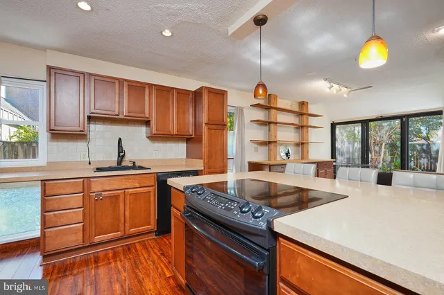 a kitchen that has a lot of cabinets in it and wooden floors