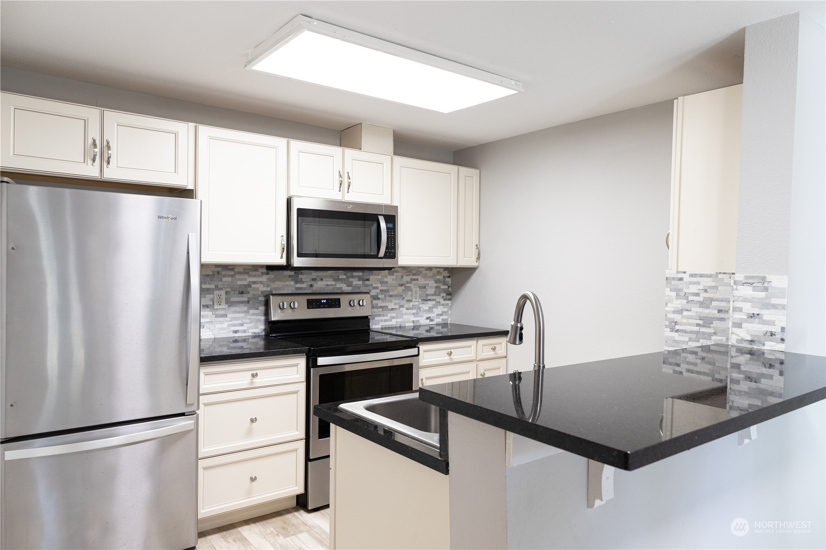 11002 Southeast Petrovitsky Road, Unit H103 Renton, WA 98055 - Photo 5 of 20 a kitchen with granite countertop a refrigerator sink and microwave