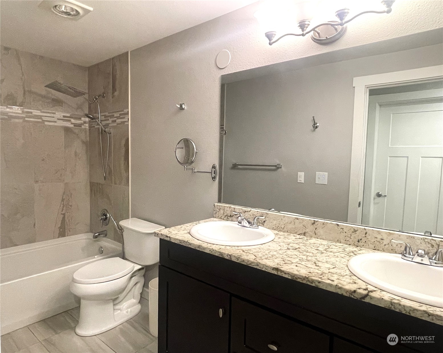 11002 Southeast Petrovitsky Road, Unit H103 Renton, WA 98055 - Photo 8 of 20 a bathroom with a granite countertop sink toilet a large mirror a shower and a bathtub