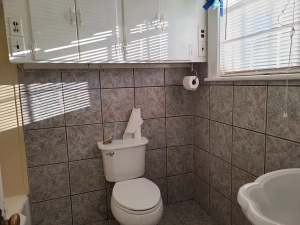 a bathroom with a toilet a sink and mirror